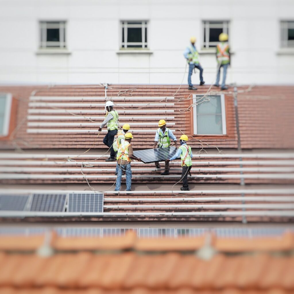 man holding solar panel on roof